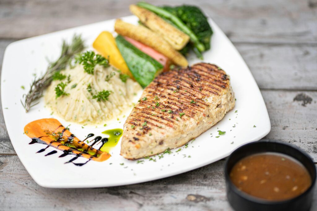 Delicious grilled chicken breast served with vibrant vegetables and mashed potatoes.